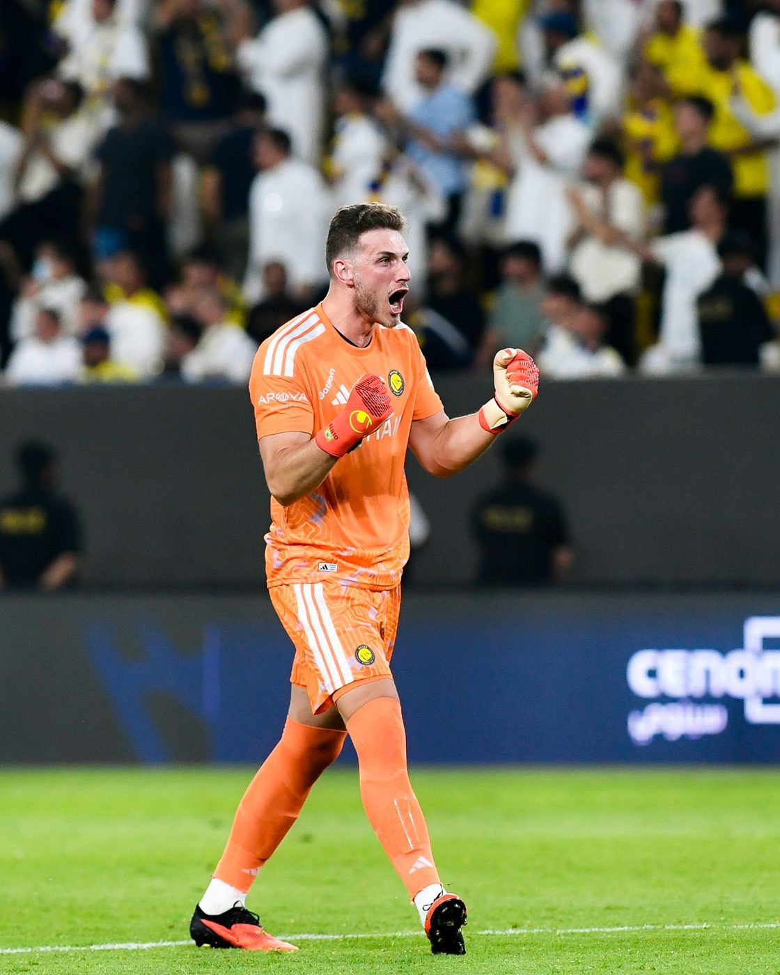 Bento comemorando com os punhos cerrados, de uniforme laranja do Al Nassr, diante da torcida